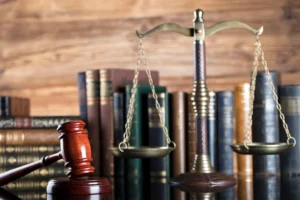 Malhete, balança da justiça e outros itens referentes ao direito sobre a mesa.