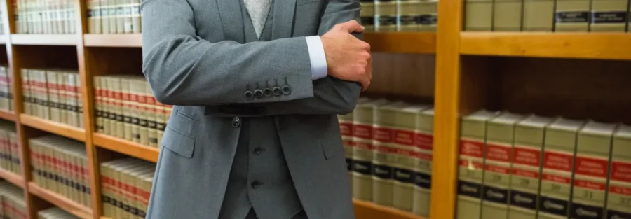 Advogado de braços cruzados em uma biblioteca