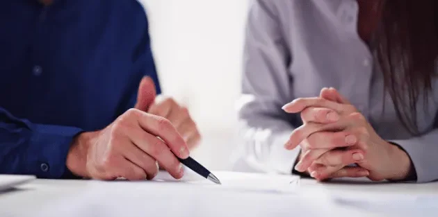 Pessoas conversando e com canetas na mão.