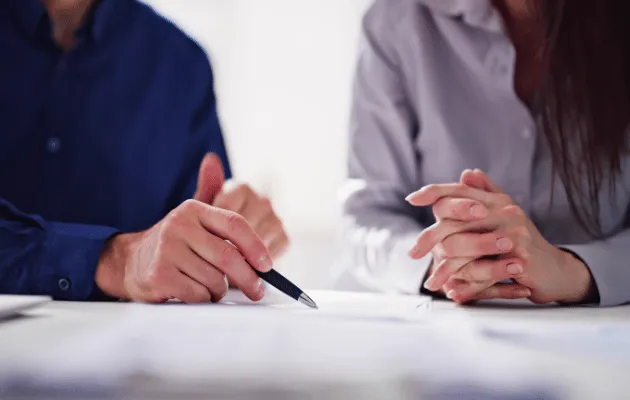 Pessoas conversando e com canetas na mão.