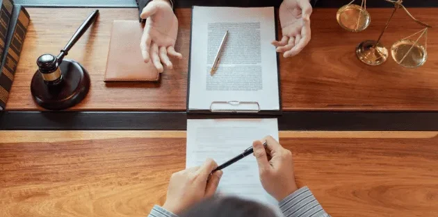Pessoas em mesa analisando representação de advogado