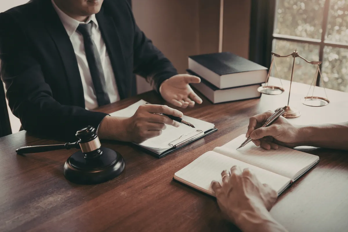 Pessoas de traje formal analisando anotações em caderno
