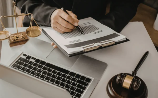 Inidoneidade Moral na OAB Pessoa escrevendo em documento e trabalhando com uso de computador